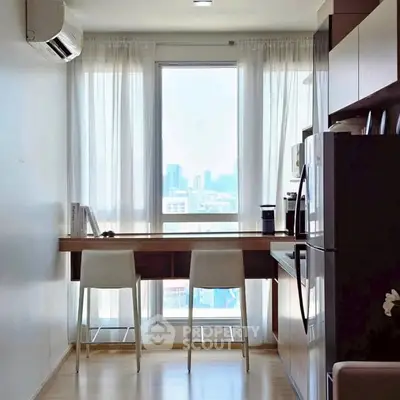Modern kitchen with sleek design, featuring a breakfast bar and city view through large window.