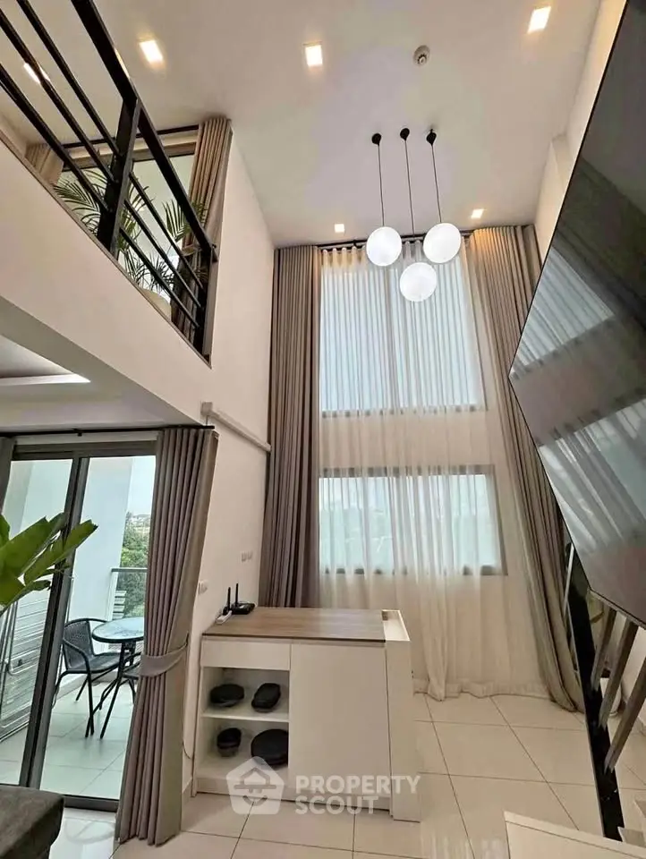 Stunning modern loft with high ceilings and elegant decor, featuring a spacious balcony and stylish lighting.