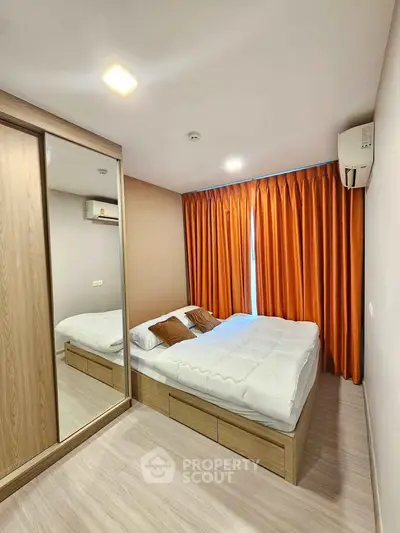 Modern bedroom with mirrored wardrobe and vibrant orange curtains