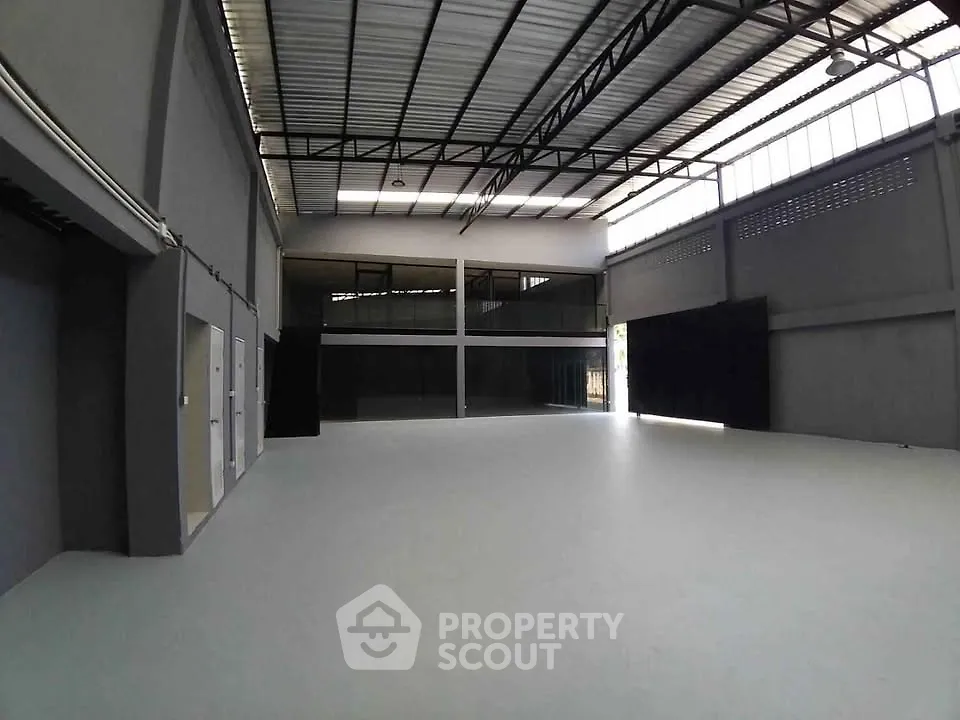 Spacious industrial warehouse with high ceilings and ample natural light.