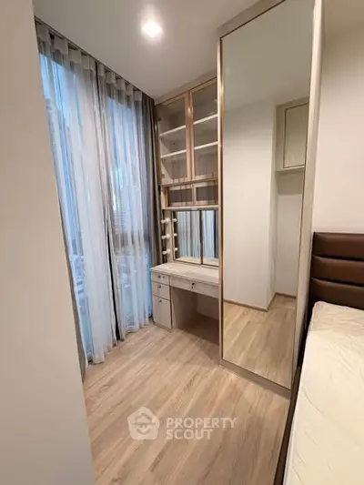 Modern bedroom with floor-to-ceiling windows and built-in wardrobe in a stylish apartment.