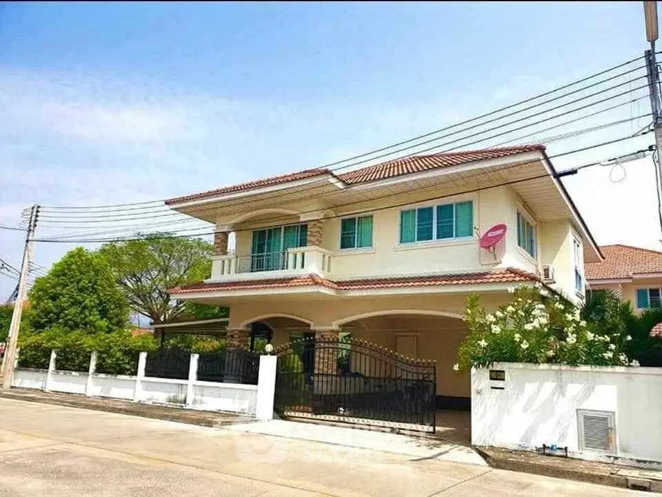 Charming two-story house with balcony and lush garden in a serene neighborhood.