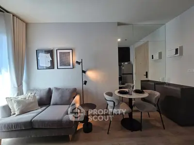 Modern living room with stylish decor and dining area in open layout apartment.