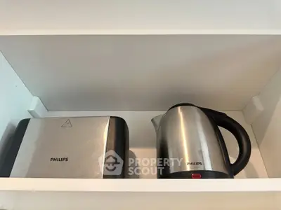 Modern kitchen shelf with stainless steel toaster and electric kettle, perfect for contemporary living.