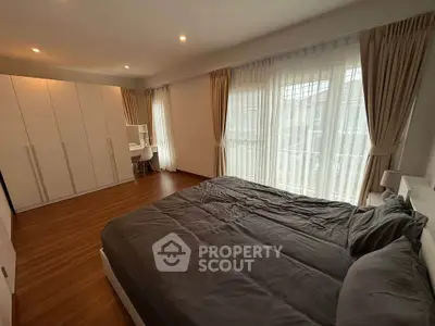 Spacious bedroom with large windows and modern furnishings, ideal for comfort and relaxation.