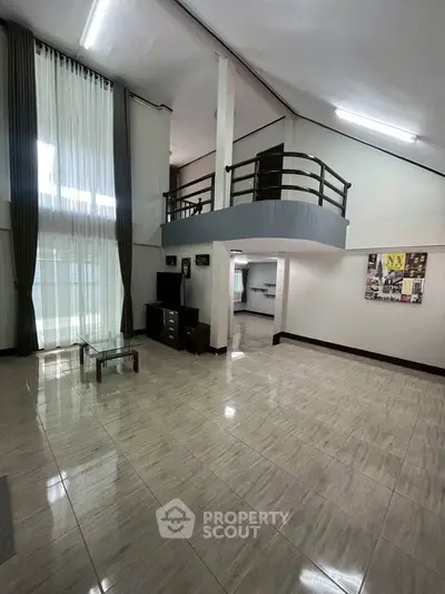 Spacious modern living room with high ceilings and mezzanine, perfect for luxury living.