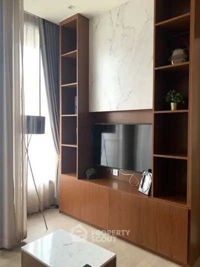 Modern living room with elegant wooden shelving and marble accents, featuring a sleek TV setup and stylish decor.