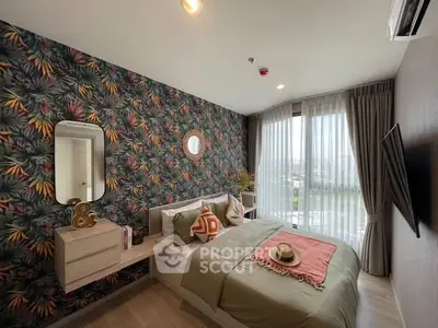 Stylish bedroom with vibrant wallpaper and modern decor, featuring a large window with city view.