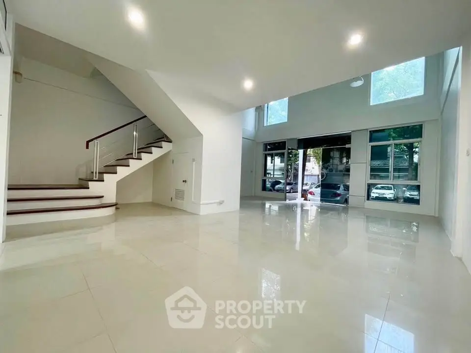 Spacious modern living room with high ceilings and large windows offering natural light.