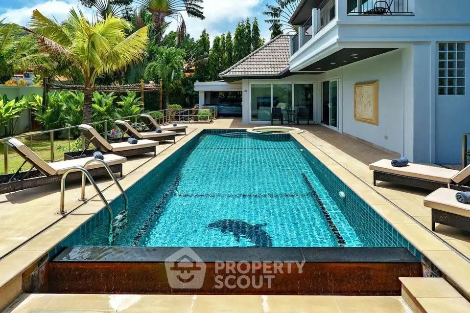 Luxurious modern villa with private pool and sun loungers in tropical setting.