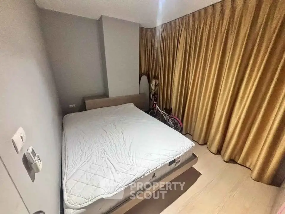 Cozy bedroom with golden curtains and a bicycle, perfect for urban living.
