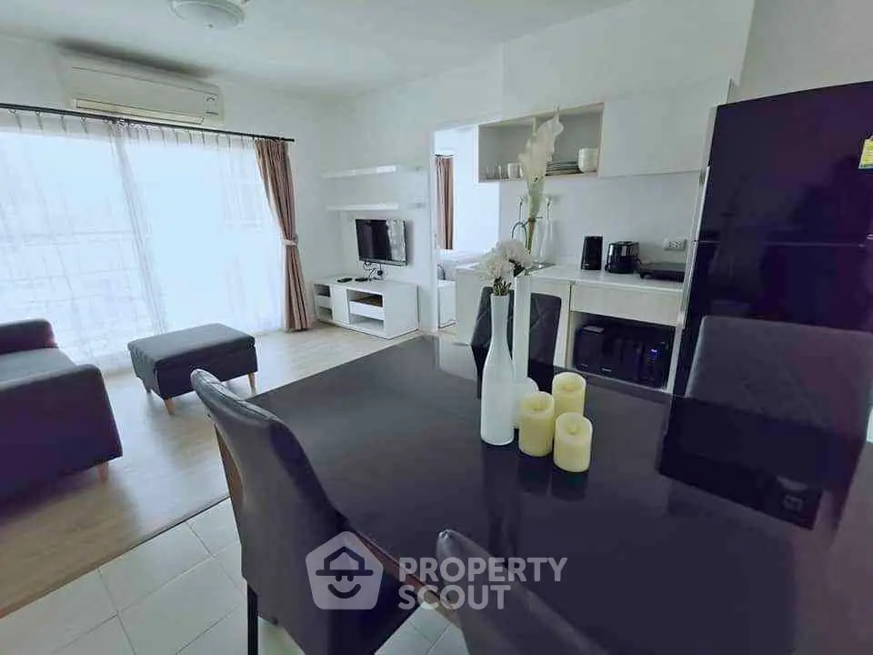 Modern open-plan living room with dining area and sleek kitchen appliances.