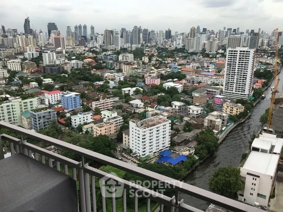 Stunning cityscape view from a high-rise balcony overlooking urban skyline and river.