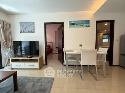 Modern living room with dining area, TV, and access to bedroom and bathroom.