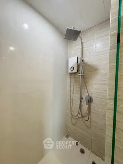 Modern bathroom shower with sleek design and rainfall showerhead in contemporary apartment.
