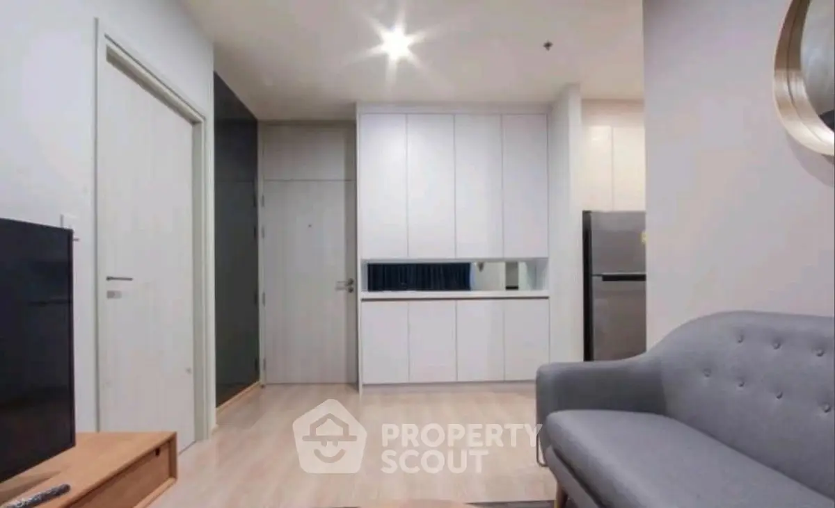 Modern living room with sleek furniture and open kitchen layout in a stylish apartment.