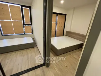 Modern minimalist bedroom with wooden flooring and natural light