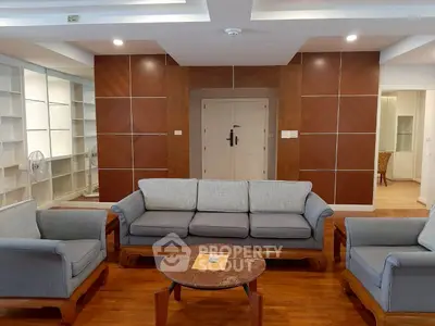 Spacious living room with elegant furniture and wooden flooring in a modern apartment.