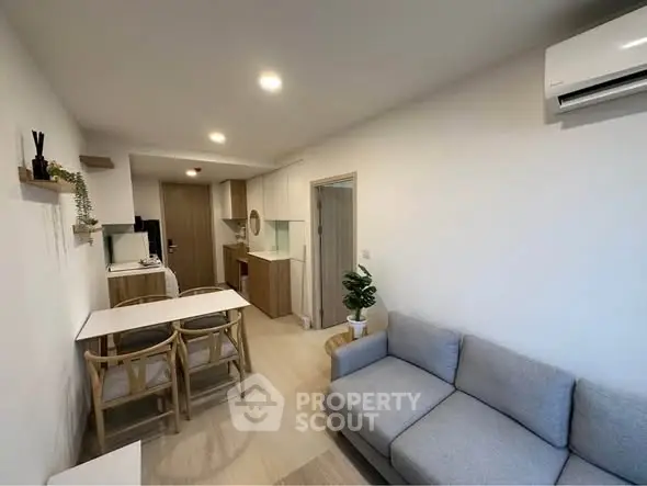 Modern living room with cozy sofa and dining area in open layout apartment.