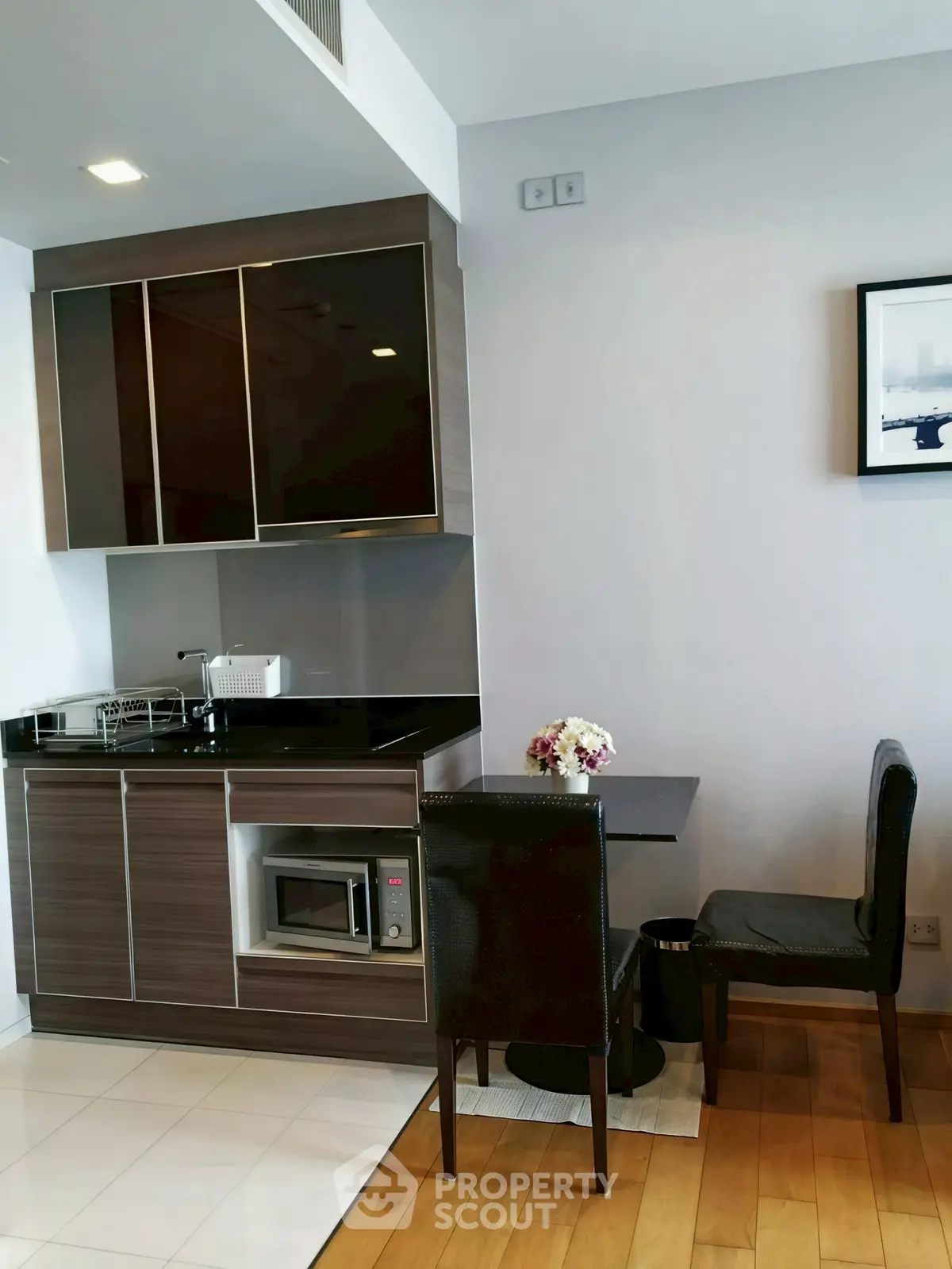 Modern kitchen with sleek cabinetry and dining area in a stylish apartment.