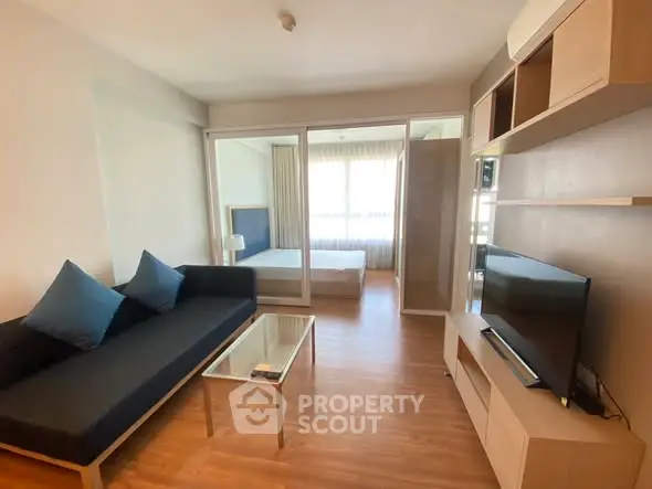 Modern living room with sleek furniture and bedroom view