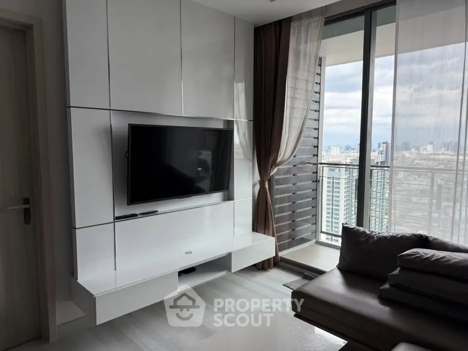 Modern living room with sleek TV unit and city view balcony