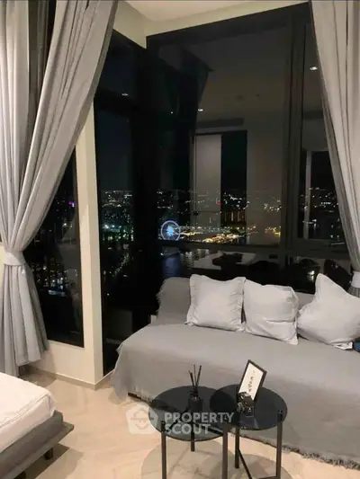 Luxurious living room with stunning city view and elegant decor at night.