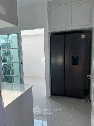 Modern kitchen with sleek black refrigerator and bright natural lighting