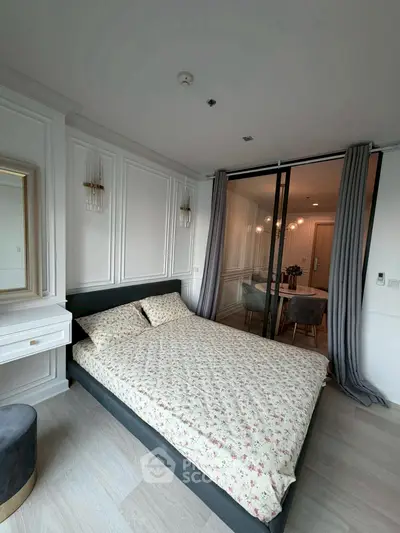 Modern bedroom with elegant decor and sliding glass doors leading to dining area.