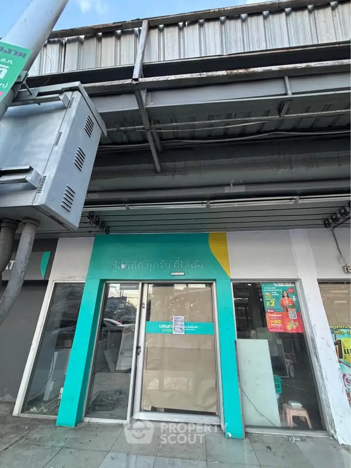 Street-level view of a commercial property with glass door and teal accents, ideal for retail or office space.