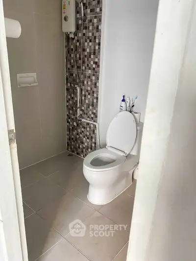 Modern bathroom with tiled shower area and white toilet, perfect for compact spaces.