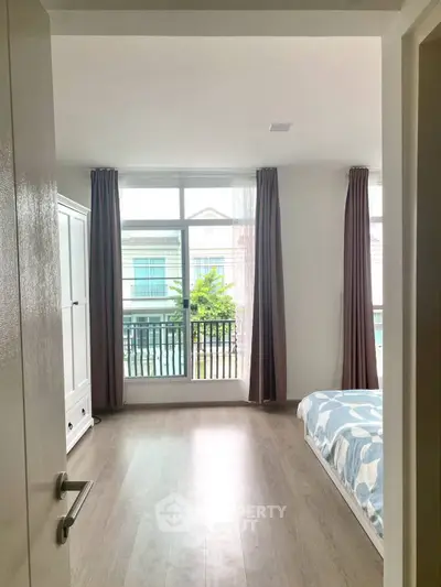 Bright bedroom with large window and modern decor, perfect for cozy living.