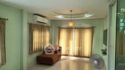 Spacious living room with modern lighting and large windows for natural light.