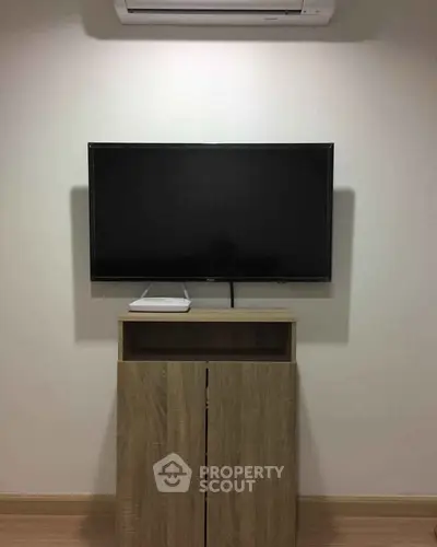 Modern living room with wall-mounted TV and sleek wooden cabinet