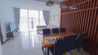 Modern living and dining area with sleek furniture and large windows in a stylish apartment.