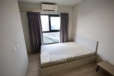 Modern bedroom with large window and city view in high-rise apartment