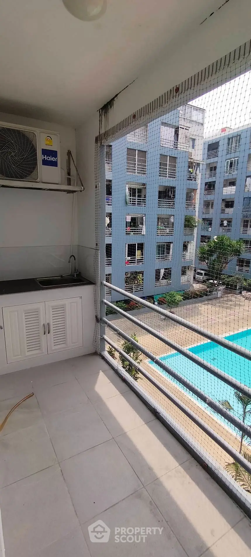 Spacious balcony with pool view in modern apartment complex