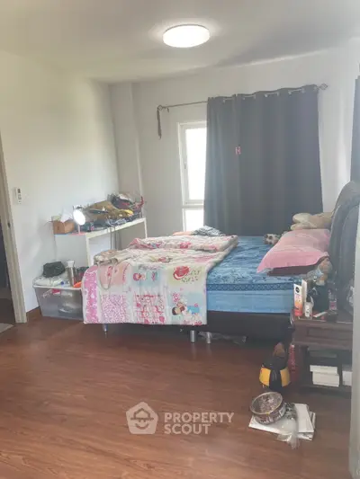Cozy bedroom with wooden flooring and natural light