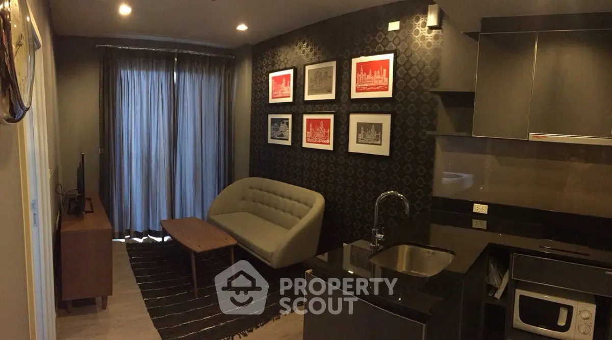 Modern living room with stylish decor and compact kitchen in a cozy apartment.