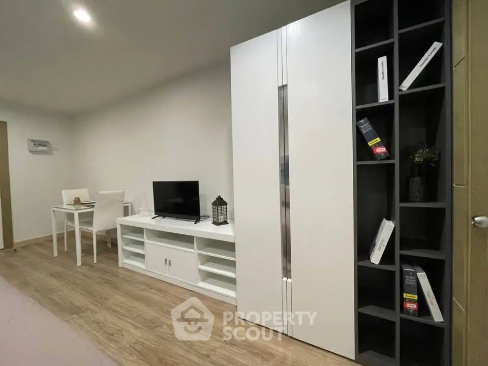 Modern living room with sleek white furniture and wooden flooring