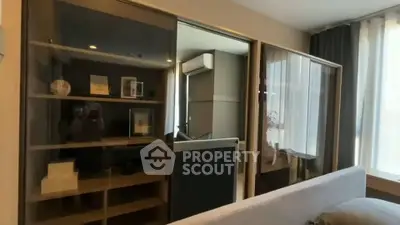 Modern living room with sleek storage and large windows in a stylish apartment.