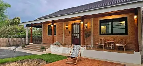 Charming brick house with inviting porch and lush garden, perfect for relaxation and outdoor enjoyment.