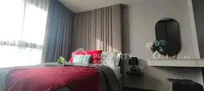 Stylish bedroom with modern decor and natural light, featuring elegant bedding and a chic vanity area.