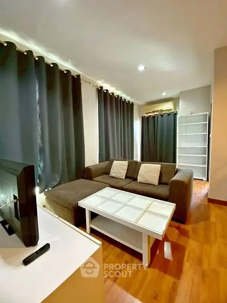 Cozy living room with modern decor and ample natural light, featuring a comfortable sofa and stylish shelving.
