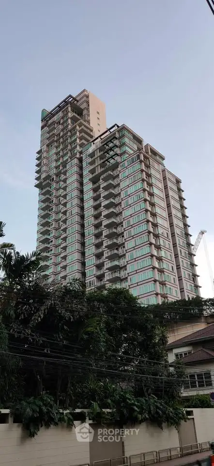 Stunning high-rise building with modern architecture and lush greenery, perfect for urban living.