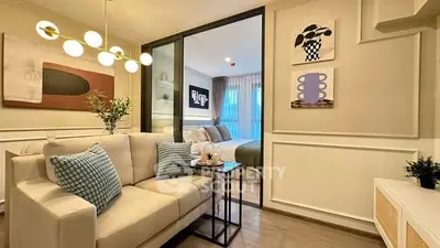 Modern living room with cozy sofa and stylish decor leading to a chic bedroom.