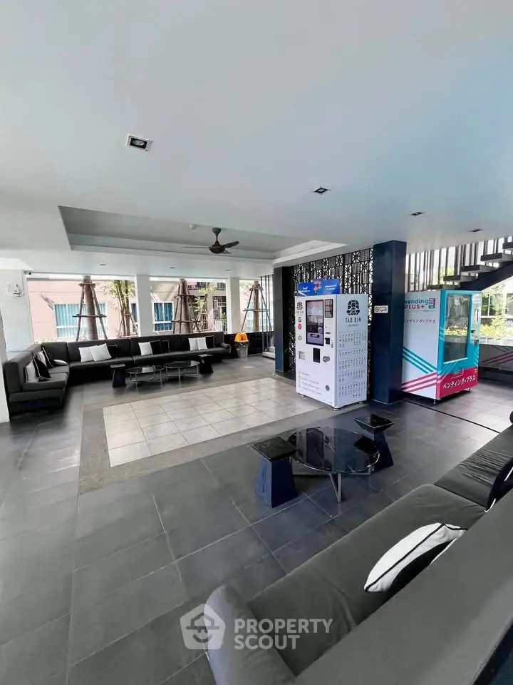 Modern lounge area with vending machines and stylish seating in a residential building.