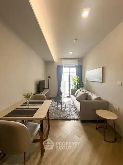 Modern living room with cozy sofa, dining table, and balcony view in stylish apartment.