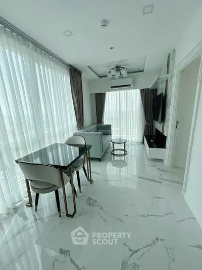 Elegant modern living room with marble flooring and large windows offering abundant natural light.