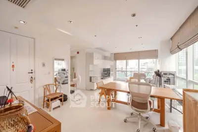 Spacious modern living room with large windows and stylish furniture in a high-rise apartment.